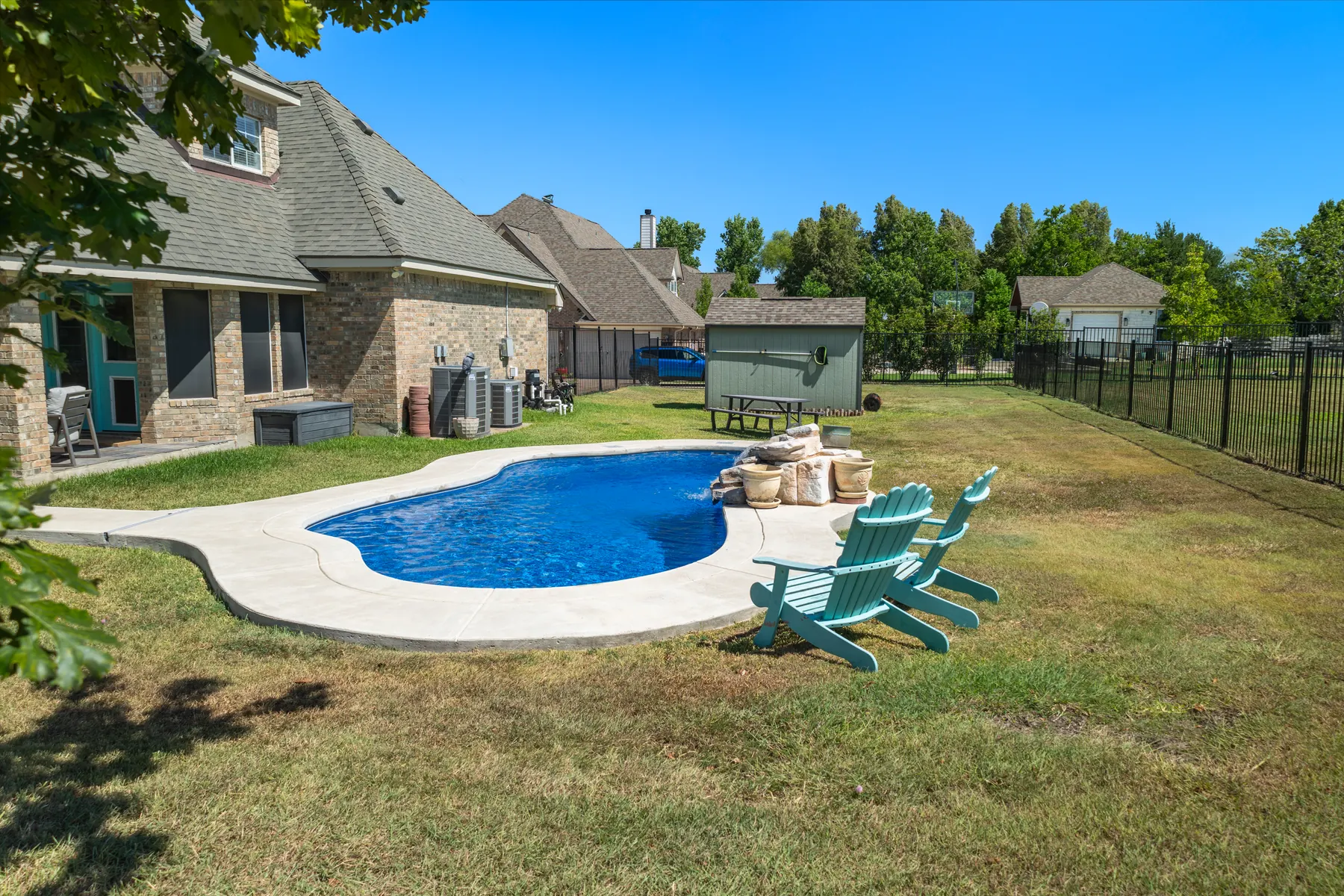 Pool and fenced backyard from an elevated angle